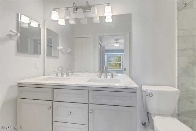 bathroom featuring double vanity, toilet, a ceiling fan, and a sink