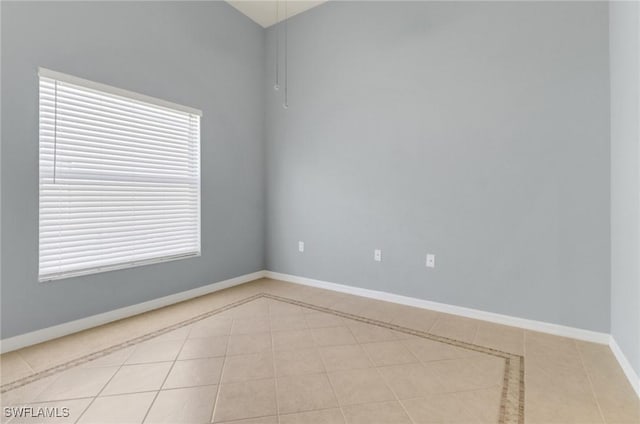 unfurnished room featuring light tile patterned floors and baseboards