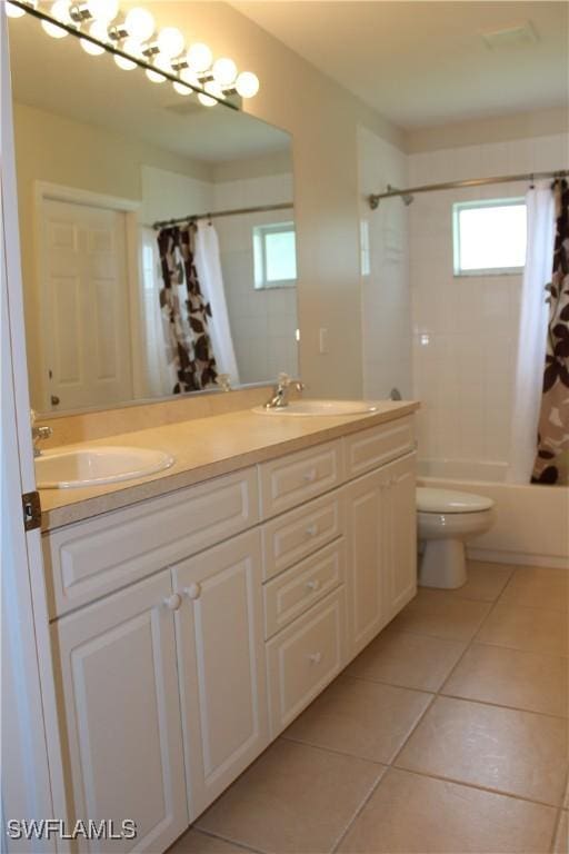 bathroom featuring tile patterned floors, toilet, shower / bath combo, and a sink