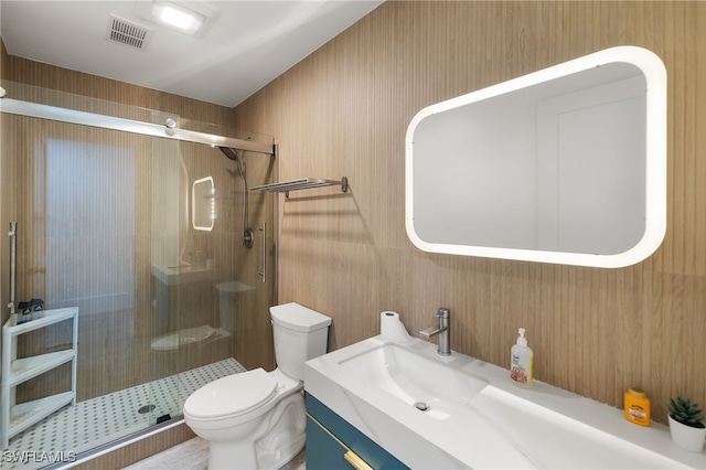 bathroom with vanity, toilet, visible vents, and a stall shower