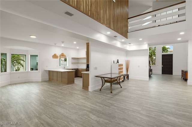 kitchen with open floor plan, a towering ceiling, visible vents, and open shelves