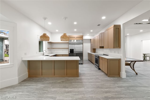 kitchen featuring a peninsula, recessed lighting, a sink, stainless steel appliances, and light countertops