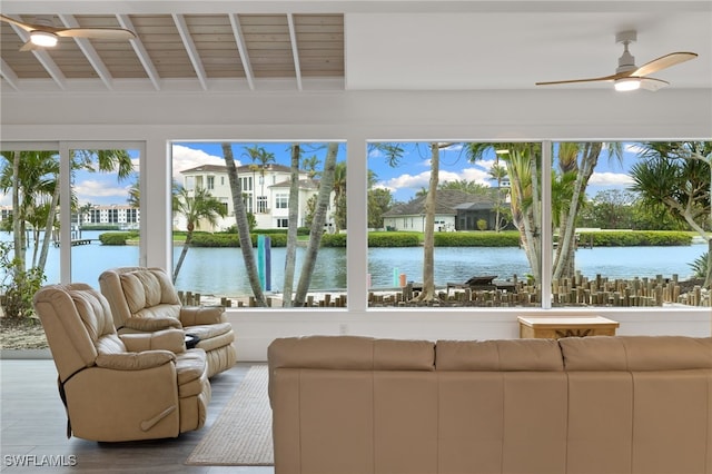 sunroom / solarium with beamed ceiling, a water view, wood ceiling, and a ceiling fan