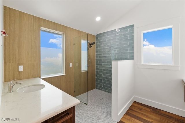 full bath featuring a walk in shower, baseboards, vaulted ceiling, wood finished floors, and vanity