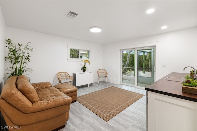 living room with recessed lighting, visible vents, and baseboards