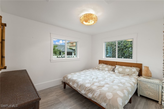 bedroom with baseboards and wood finished floors