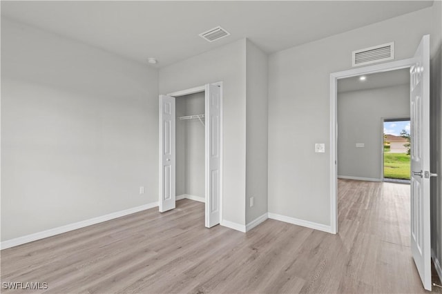 unfurnished bedroom featuring light wood finished floors, visible vents, and baseboards