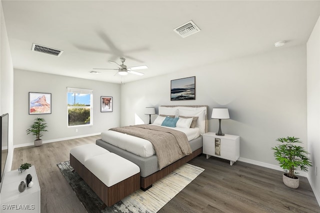 bedroom with visible vents, baseboards, and wood finished floors