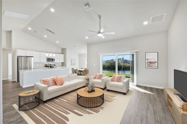 living room featuring ceiling fan, visible vents, high vaulted ceiling, and wood finished floors