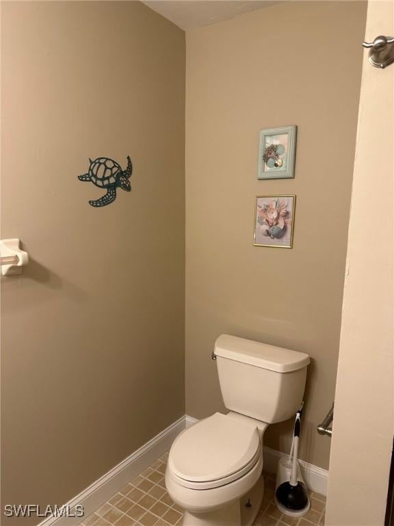 bathroom with tile patterned flooring, toilet, and baseboards