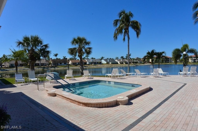 view of swimming pool with a patio area, a pool, and a water view