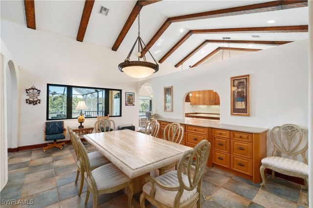 dining room featuring arched walkways, beam ceiling, a healthy amount of sunlight, and visible vents