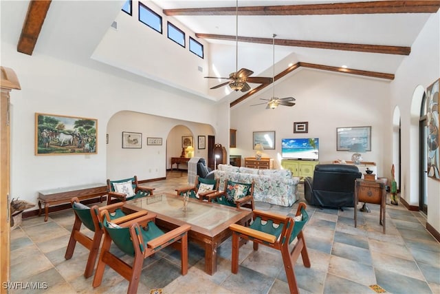 dining room featuring arched walkways, high vaulted ceiling, beam ceiling, and a ceiling fan