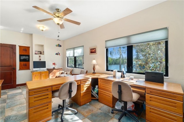 office featuring stone finish flooring, baseboards, and a ceiling fan