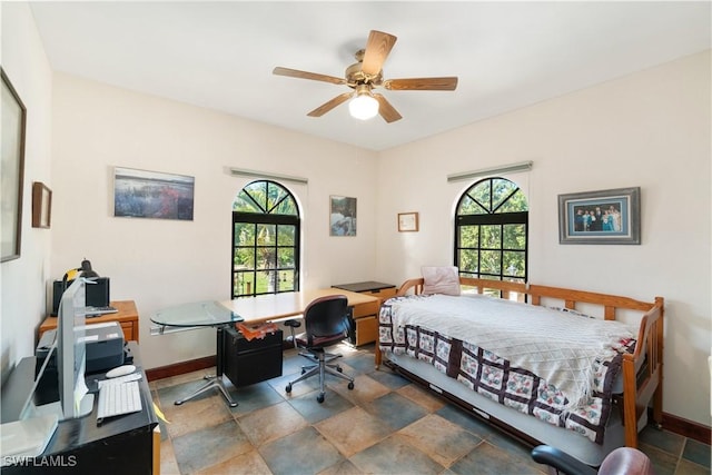 bedroom with multiple windows, a ceiling fan, and baseboards