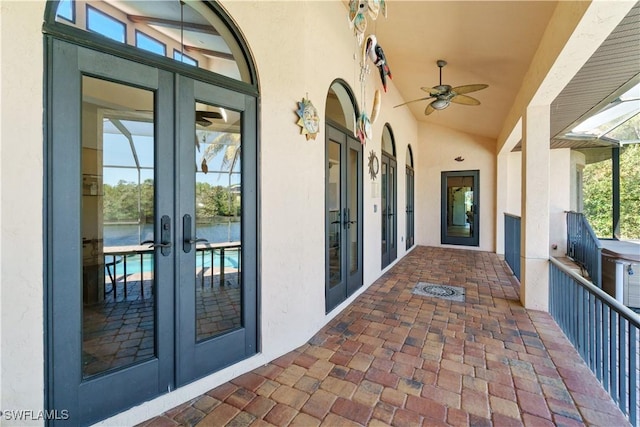 property entrance featuring stucco siding, french doors, and a ceiling fan