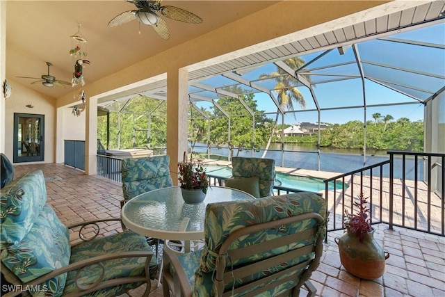 view of patio / terrace with glass enclosure, an outdoor pool, ceiling fan, and a water view