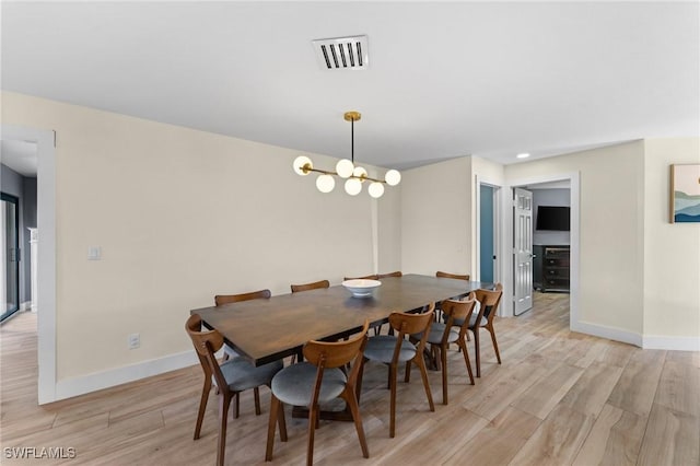 dining area with baseboards, visible vents, a chandelier, and light wood-type flooring