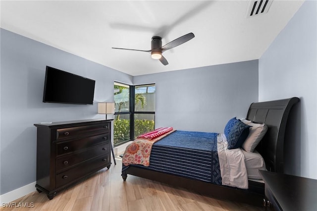 bedroom with ceiling fan, visible vents, light wood-type flooring, and baseboards