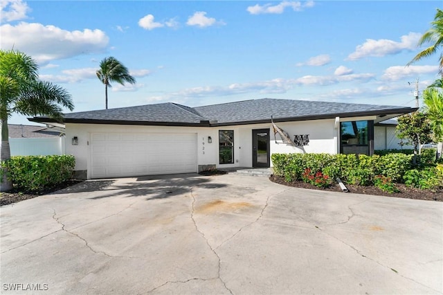 view of front of house with stucco siding, a garage, concrete driveway, and a shingled roof