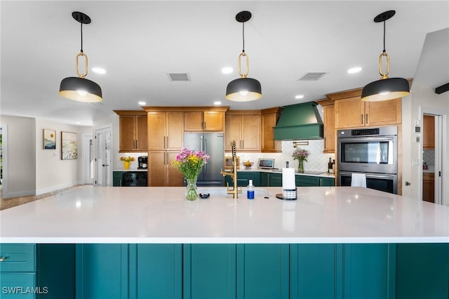 kitchen featuring premium range hood, stainless steel appliances, visible vents, and light countertops