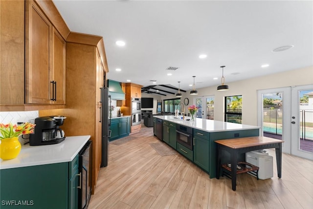 kitchen with custom range hood, french doors, green cabinets, and light countertops