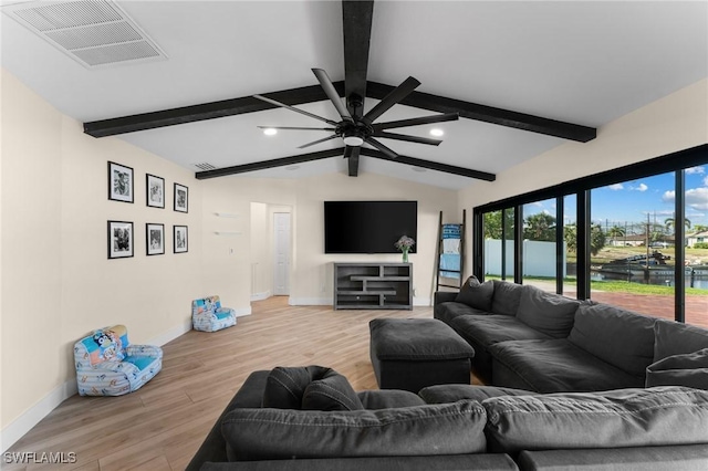 living room featuring lofted ceiling with beams, wood finished floors, visible vents, and baseboards