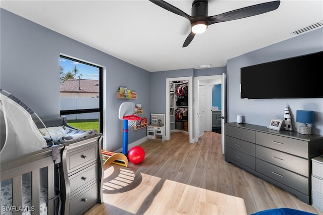 bedroom with visible vents, a ceiling fan, a closet, light wood-style floors, and a spacious closet