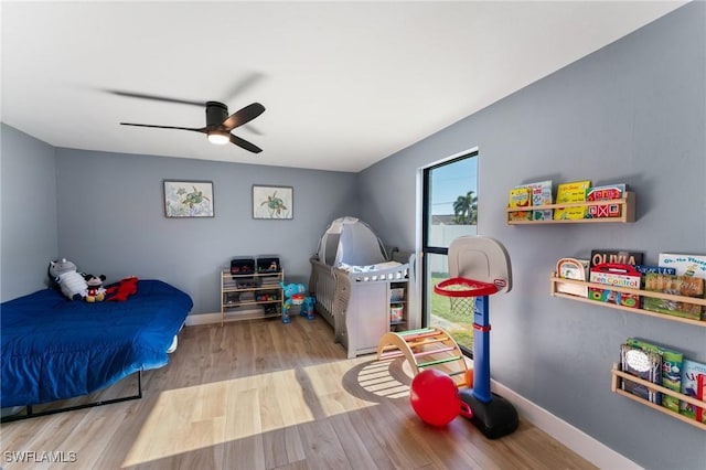 bedroom with a ceiling fan, baseboards, and wood finished floors