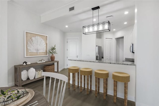 dining space with recessed lighting, visible vents, dark wood-type flooring, and ornamental molding