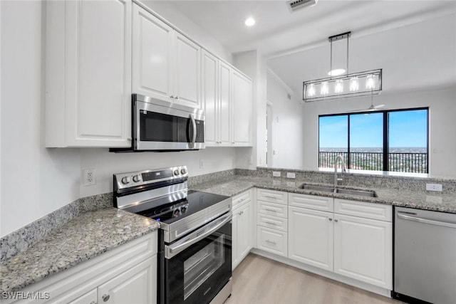 kitchen with a sink, visible vents, appliances with stainless steel finishes, and white cabinets