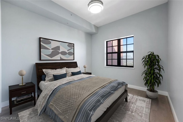 bedroom with baseboards and wood finished floors