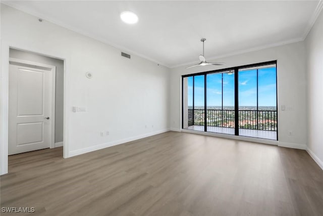 empty room with baseboards, a ceiling fan, visible vents, and ornamental molding