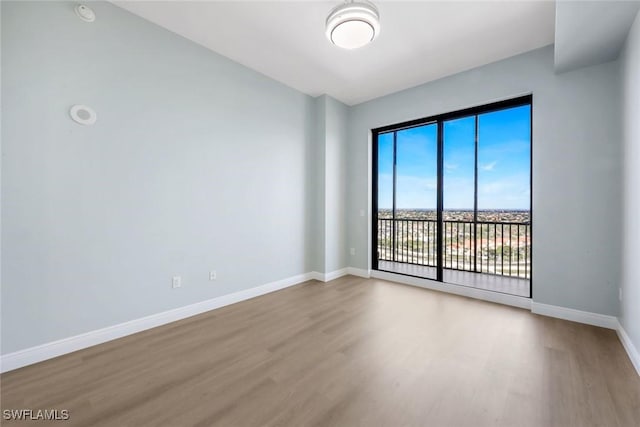 empty room with wood finished floors and baseboards