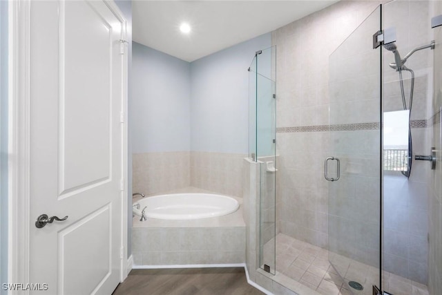 full bathroom with a shower stall, a garden tub, and wood finished floors