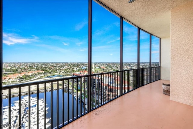 unfurnished sunroom with a city view and a water view