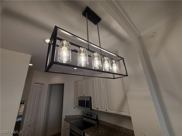 interior space featuring dark countertops, white cabinets, stainless steel appliances, and crown molding