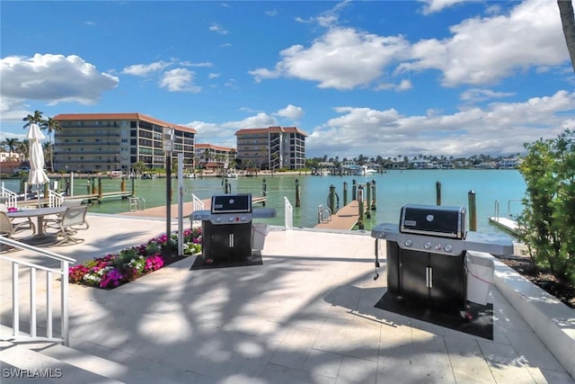 view of patio with area for grilling, a boat dock, and a water view