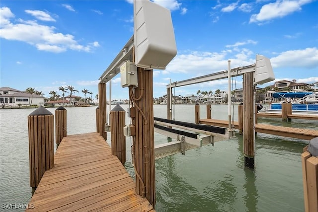 dock area featuring boat lift and a water view