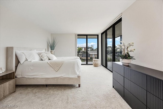 carpeted bedroom with access to exterior and a wall of windows