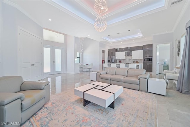 living area featuring a chandelier, visible vents, a raised ceiling, and ornamental molding