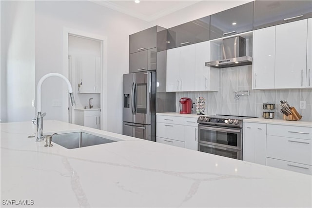 kitchen featuring a sink, backsplash, appliances with stainless steel finishes, and wall chimney exhaust hood