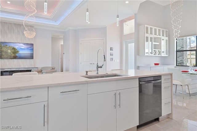 kitchen featuring open floor plan, dishwasher, ornamental molding, white cabinetry, and a sink