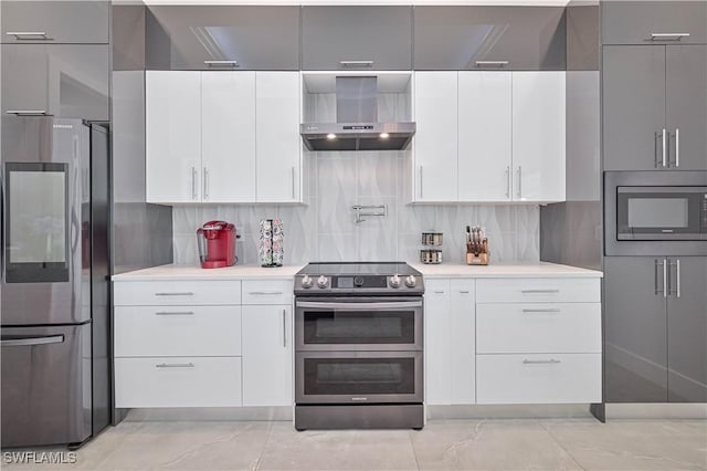 kitchen with decorative backsplash, light countertops, appliances with stainless steel finishes, wall chimney exhaust hood, and modern cabinets