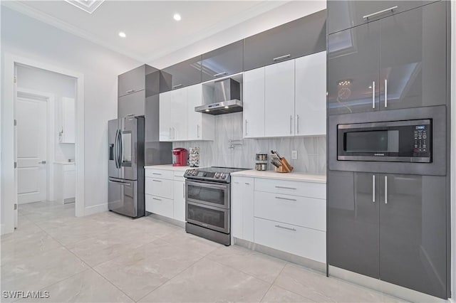 kitchen featuring backsplash, light countertops, appliances with stainless steel finishes, white cabinetry, and wall chimney exhaust hood