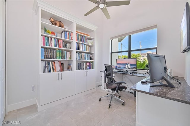 office area with a ceiling fan and baseboards