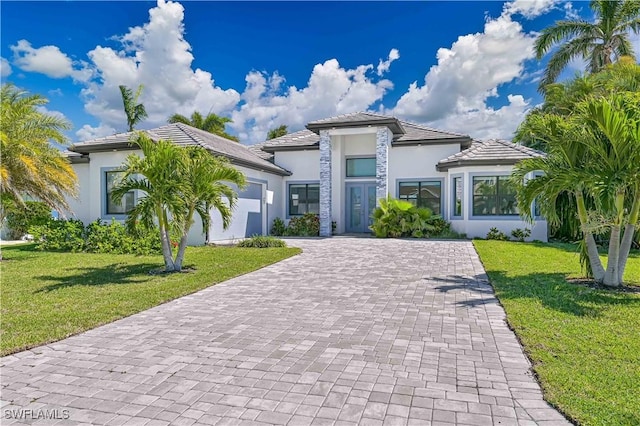 3619 SE 16th Pl, Cape Coral, FL 33904 - view of front facade featuring stucco siding, a garage, decorative driveway, and a front lawn