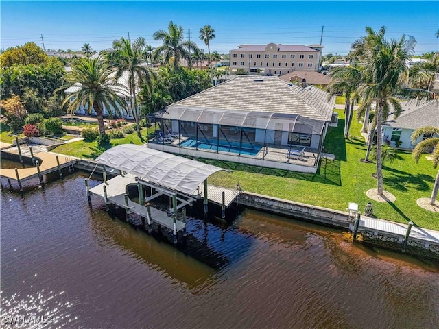 view of dock with a yard, a water view, boat lift, and a lanai