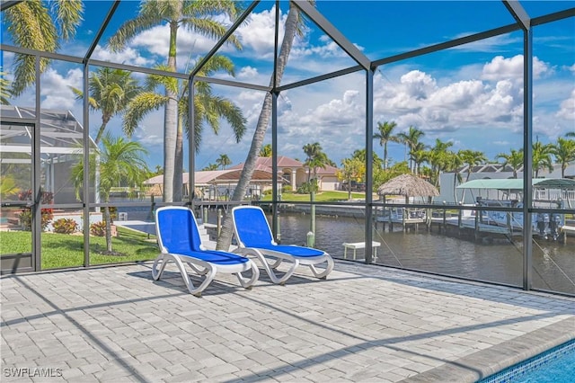 view of patio / terrace with a water view and a lanai