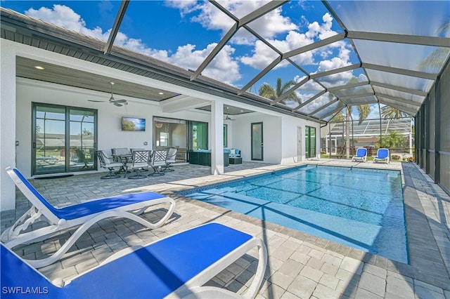 outdoor pool featuring glass enclosure, ceiling fan, and a patio area